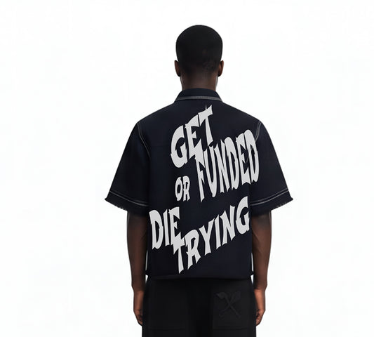 Person wearing a black shirt with white text on the back, standing against a white background