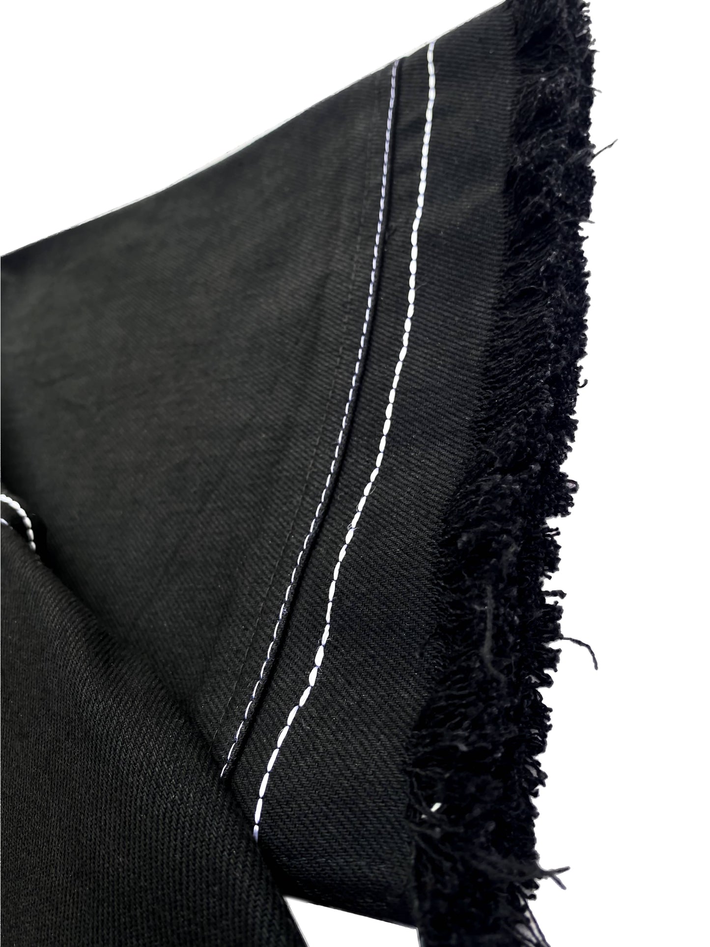 Black fabric with white stitching and frayed edges on a white background