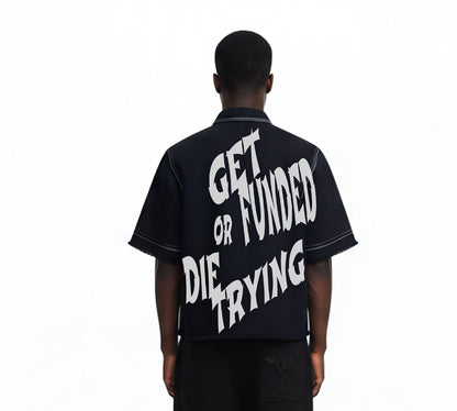 Person wearing a black shirt with white text on the back, standing against a white background