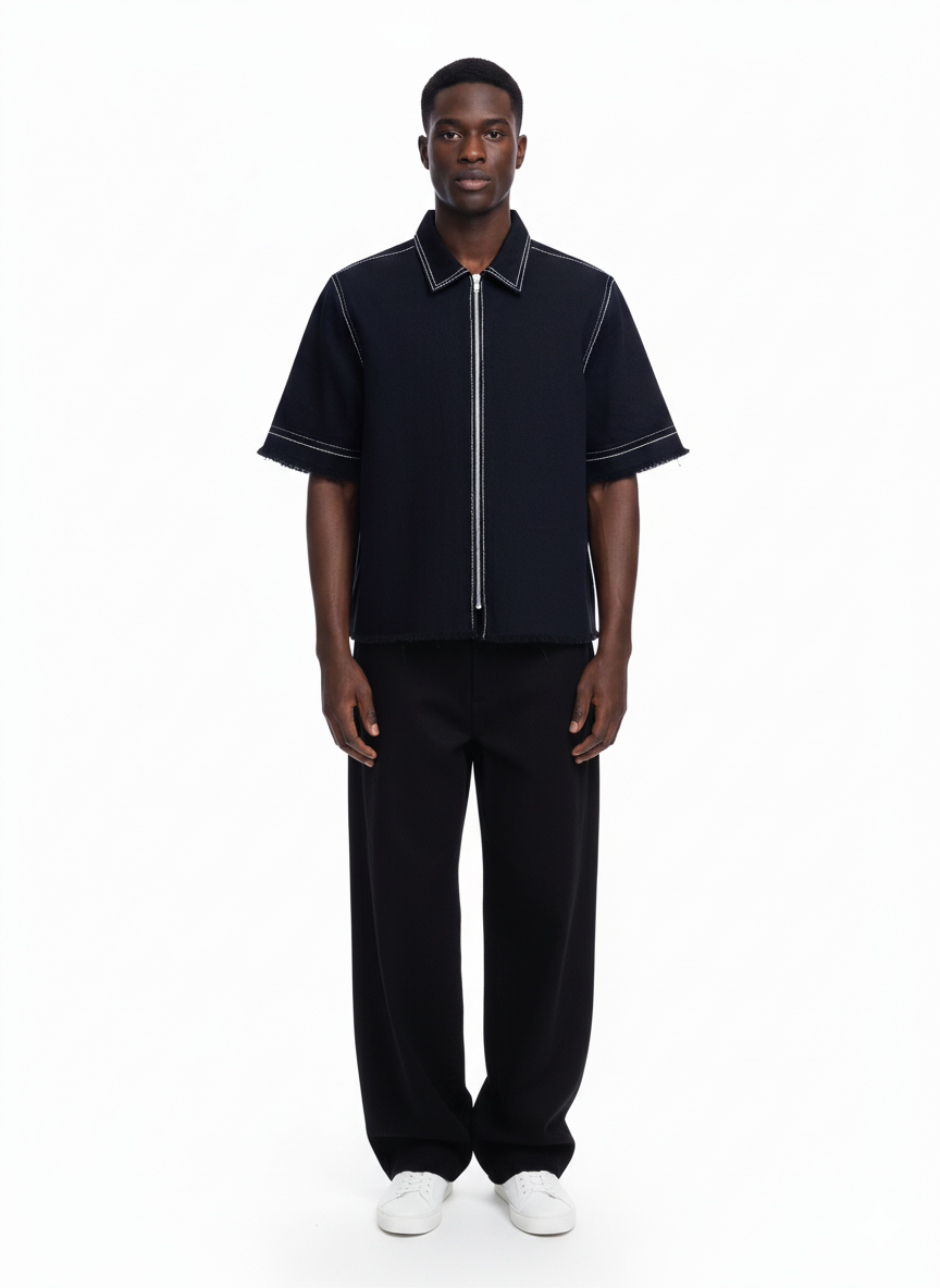 Man wearing a black zip-up shirt and pants on a white background